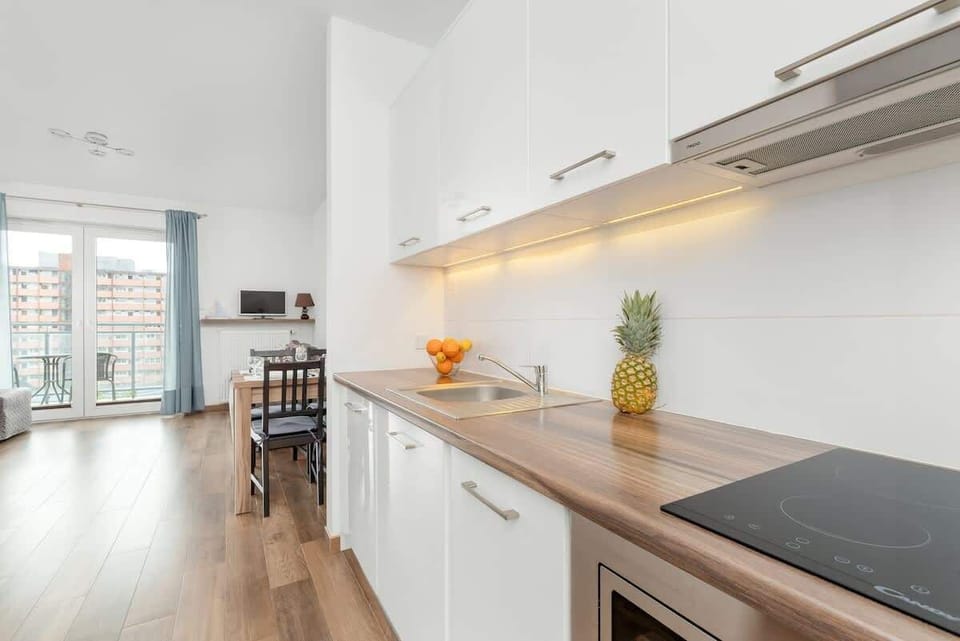 A cozy kitchenette with modern cabinets, countertop, and lighting is perfect for preparing meals.