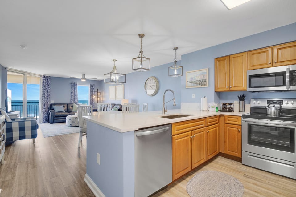 Your open-concept kitchen flows seamlessly into the living area, where ocean views greet you through floor-to-ceiling windows.