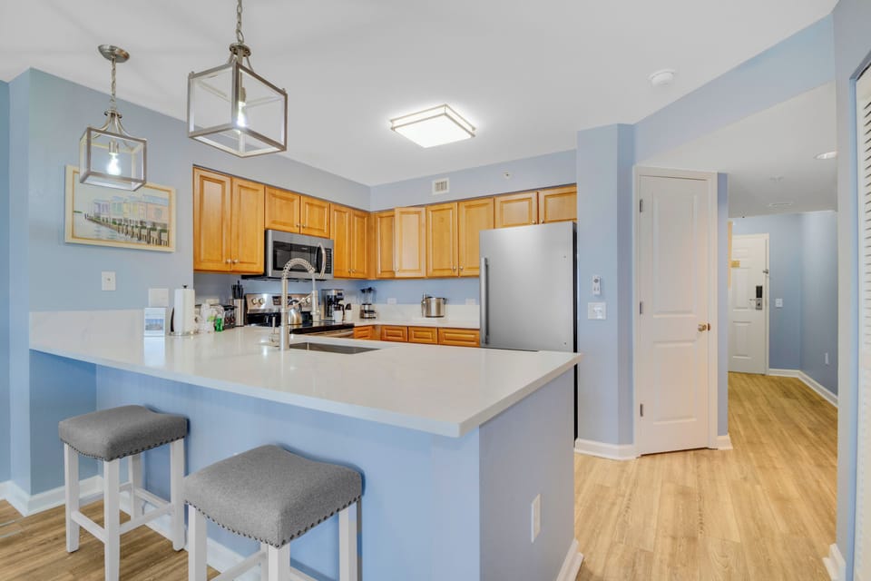 Cook your favorite meals in this bright, fully-equipped kitchen featuring stainless steel appliances and a convenient breakfast bar.