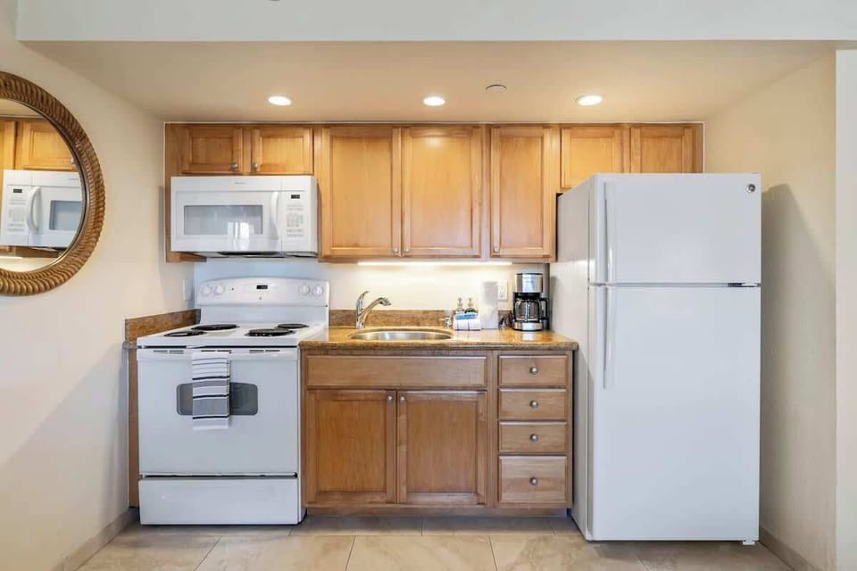 Kitchen features, oven, microwave fridge/freezer, and a coffee maker