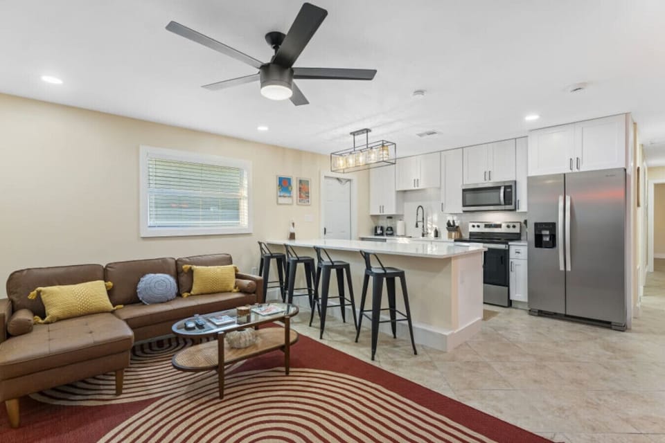 Cocoa Beach Open Layout | Stainless kitchen, bar seating & airy lounge with warm coastal textures