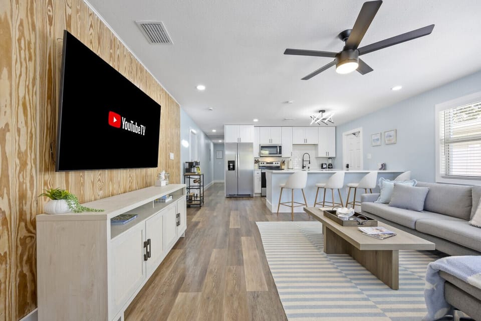 Cocoa Beach Living Area | Comfy sectional, sleek marble island, and airy coastal charm