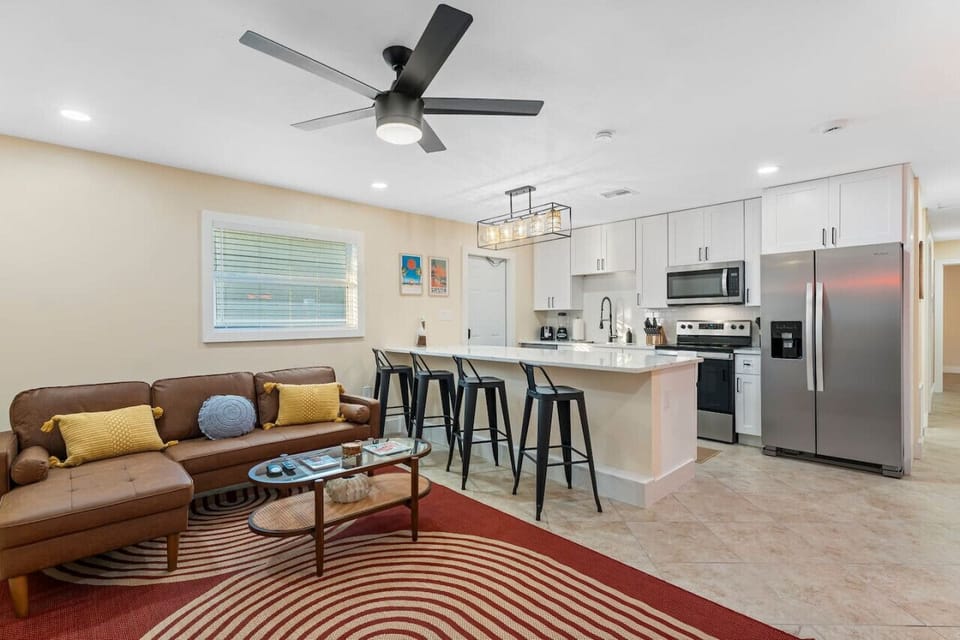 Cocoa Beach Living Room | Bright open layout with a comfortable sectional, contemporary kitchen, and soft, calming tones.