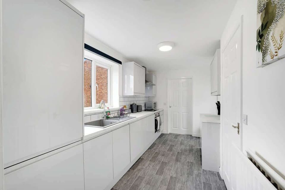Kitchen equipped with all essentials, including a oven, fridge and full cookware set.