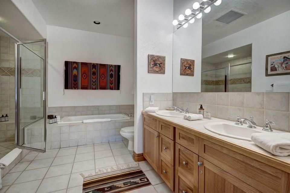 Spacious bathroom showcasing double sinks, a glass shower, and a luxurious soaking tub for ultimate relaxation.