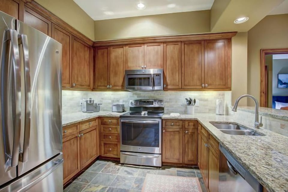 The gourmet kitchen showcases elegant wooden cabinetry, modern stainless steel appliances, and granite countertops, perfect for culinary adventures.