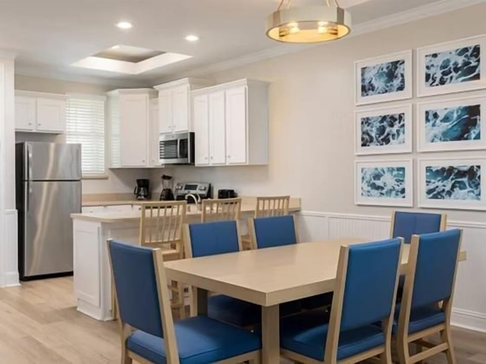 Blue dining chairs around a wood-topped table — a bright spot for shared meals
