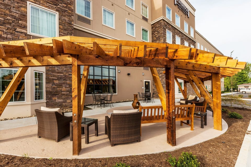 Pergola with lounge seating on the outdoor patio — a good spot to catch some sun between meals