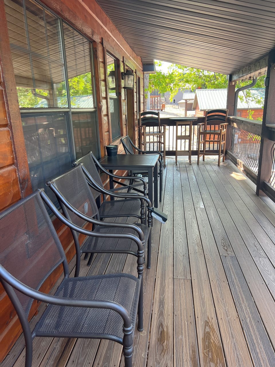 Covered front porch with seating, table and chairs.