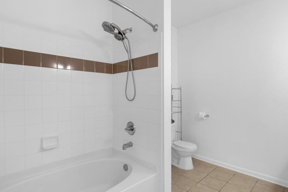 Bright bathroom with tub-shower combo and clean, functional design
