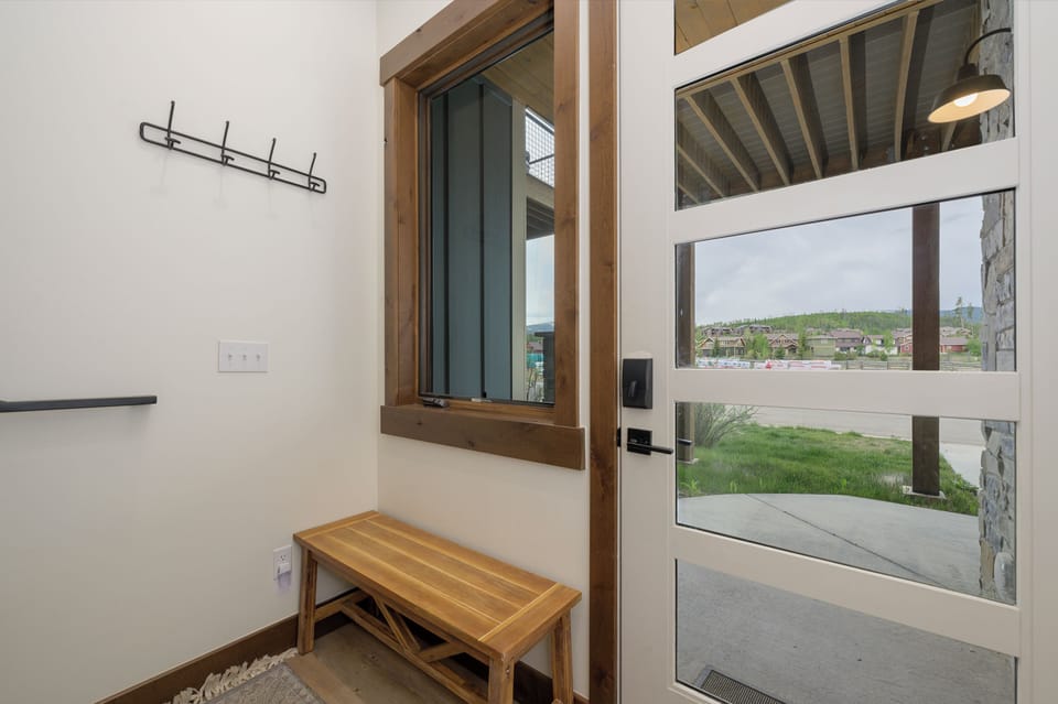 - Convenient entry area with wooden bench and wall hooks for coats or gear - Window and glass paneled door let in natural light for a bright welcome - Perfect drop zone for bags, shoes, or jackets as you come in and out