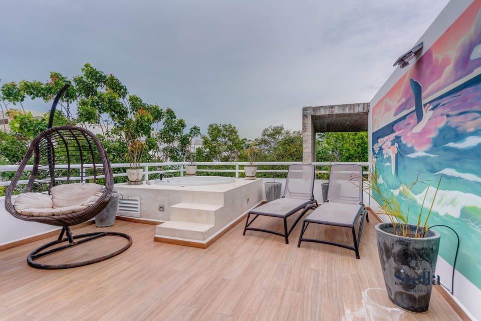 Your own private jungle rooftop lounge with a spa tub overlooking lush foliage