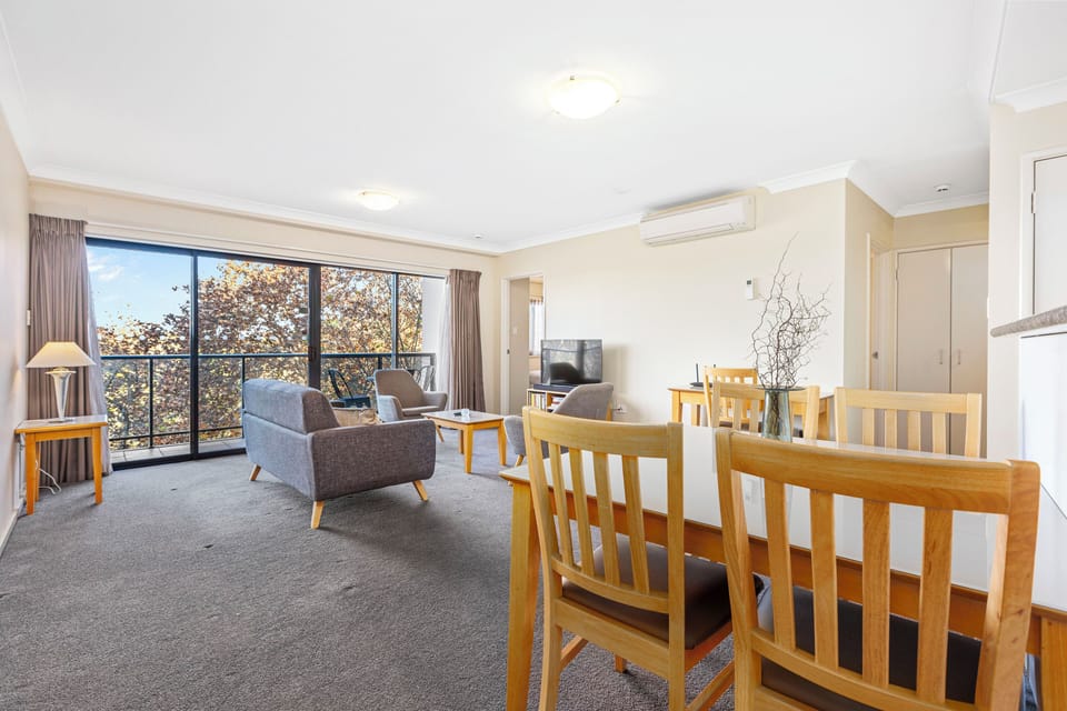 The cozy living room features a plush sofa and armchair, perfect for unwinding after a day of exploring or catching up on your favorite shows on the TV.