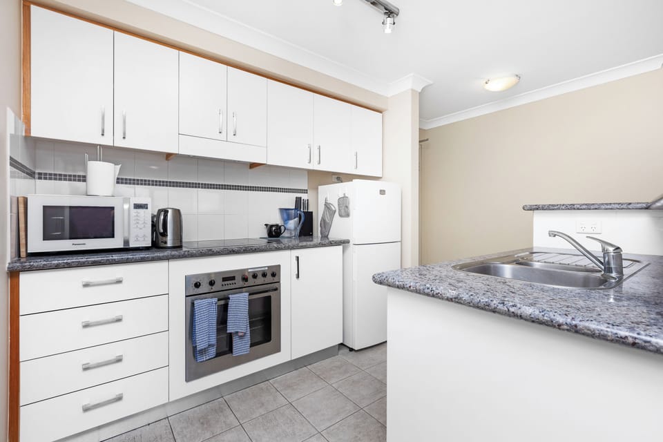 Discover a bright and functional kitchen, fully equipped with modern appliances. Enjoy ample counter space for meal preparation and a double sink for convenience.
