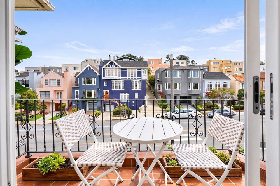 Enjoy your morning coffee on this charming balcony with outdoor seating and beautiful neighborhood views.