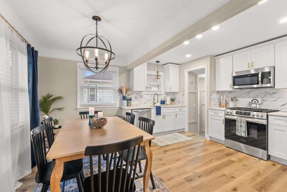 Bright dining space w/ statement light fixture & open flow to kitchen