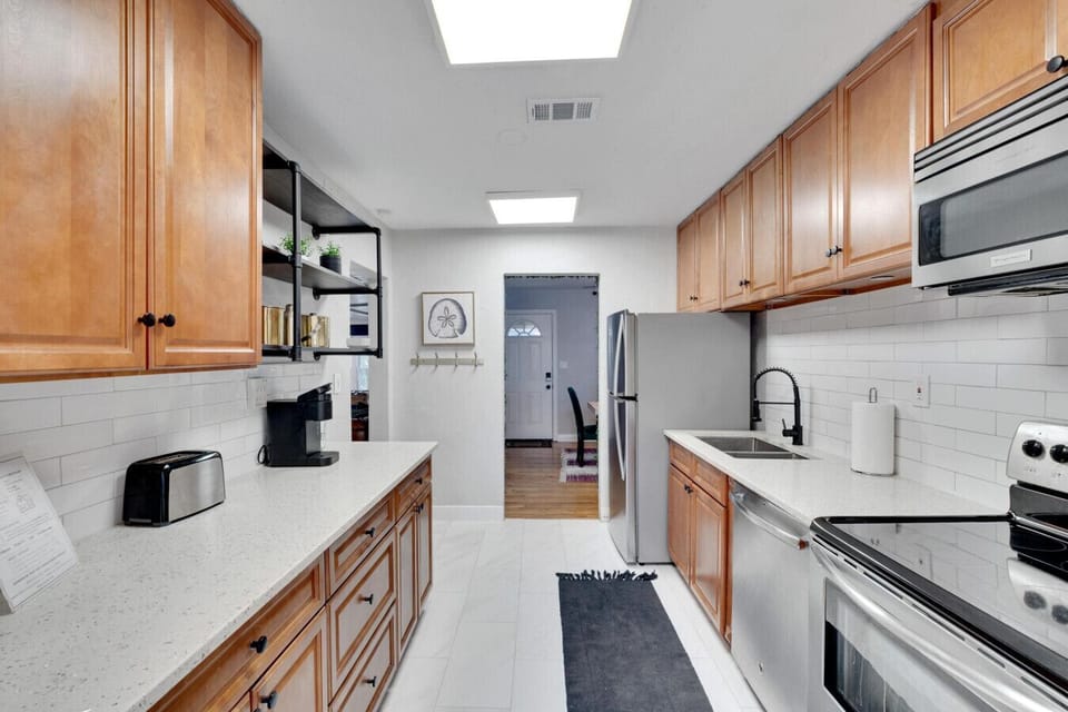 Charming shotgun kitchen that seamlessly opens up into a cozy breakfast nook