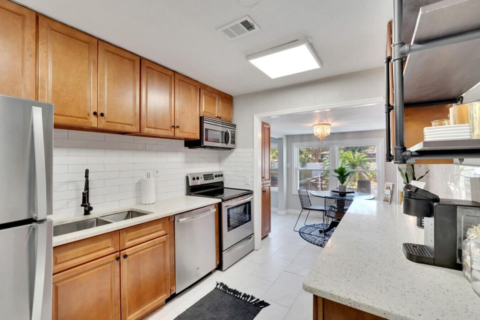 Charming shotgun kitchen that seamlessly opens up into a cozy breakfast nook