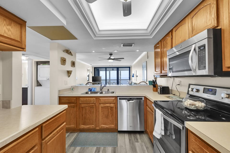 The kitchen has abundant cabinets and counter space and is equipped with full-size stainless steel appliances.