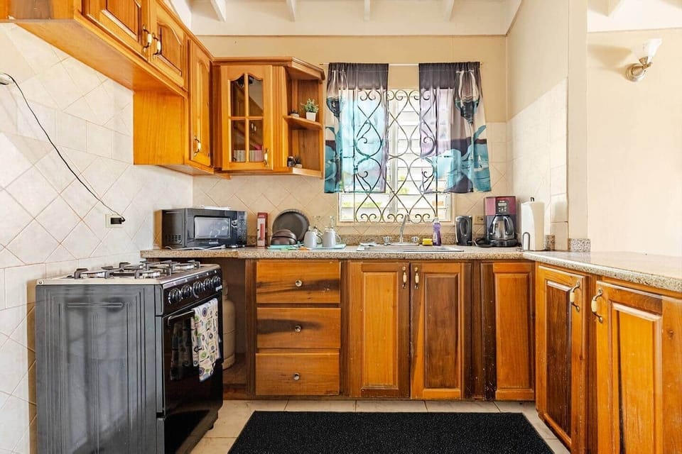 Welcoming kitchen provides essential appliances and everything needed for a comfortable Jamaican get
