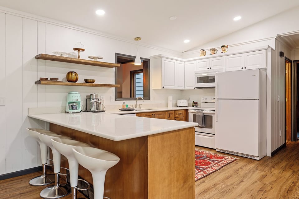 Stylish kitchen w/ island seating, open shelving & everything you need for easy meals at home.