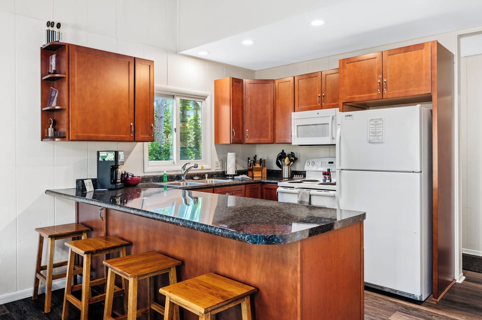 Bright kitchen w/ bar seating, granite counters & plenty of space to cook & connect.