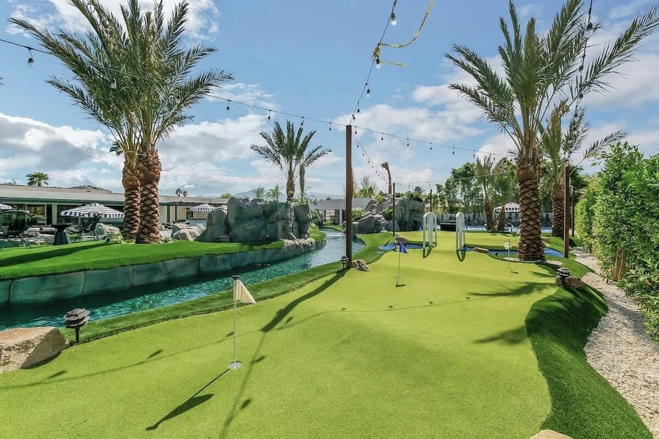 Practice your short game on this private putting green framed by palms and string lights.