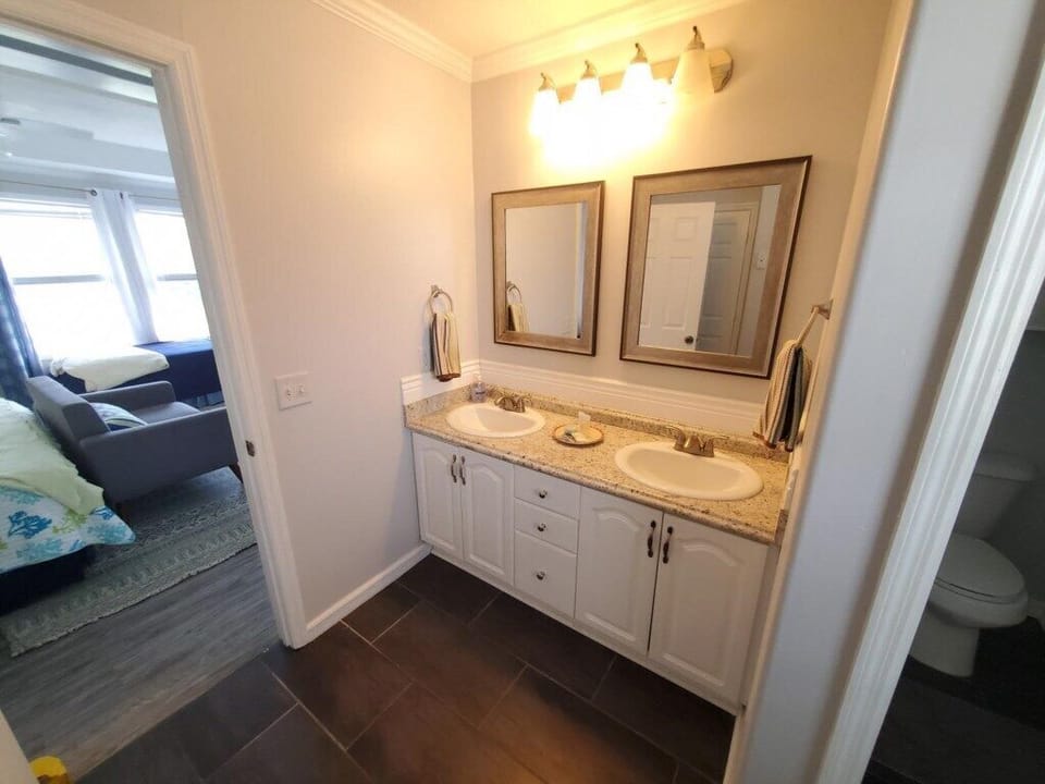 Bright bathroom with double vanity and ample lighting.