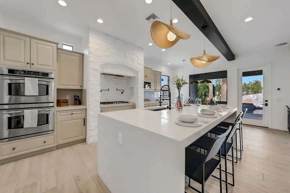 This expansive kitchen island offers bar seating, pendant lighting, and a sleek layout ideal for casual meals or hosting guests.