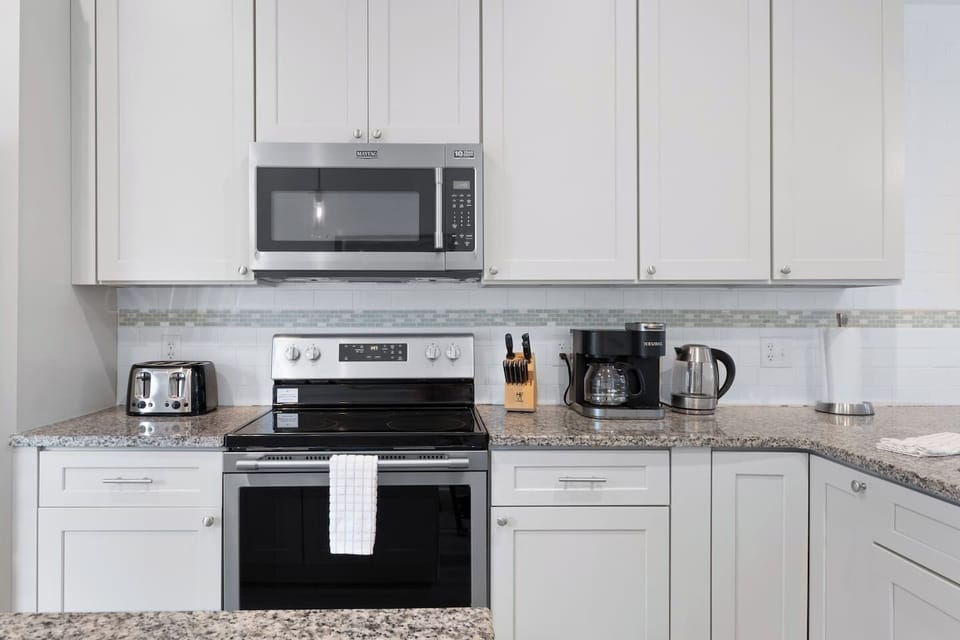 A sleek, modern kitchen featuring all stainless steel appliances, equipped with everything you need to cook and enjoy meals at home—whether it’s a quick breakfast or a gourmet dinner.