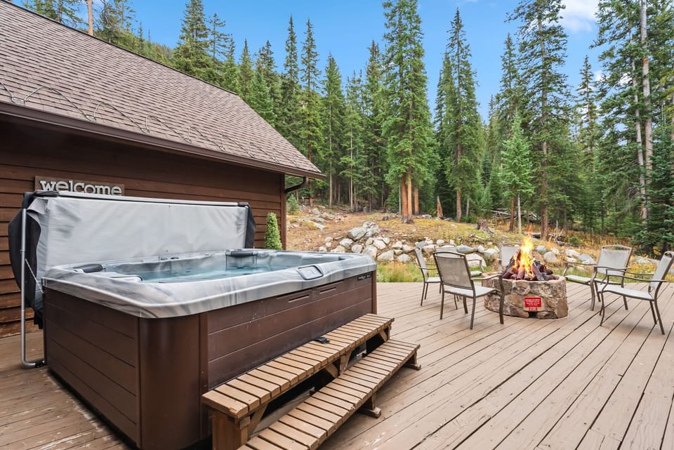 An expansive deck wraps around nearly the entire home and includes a private hot tub, gas grill, and fire pit.
