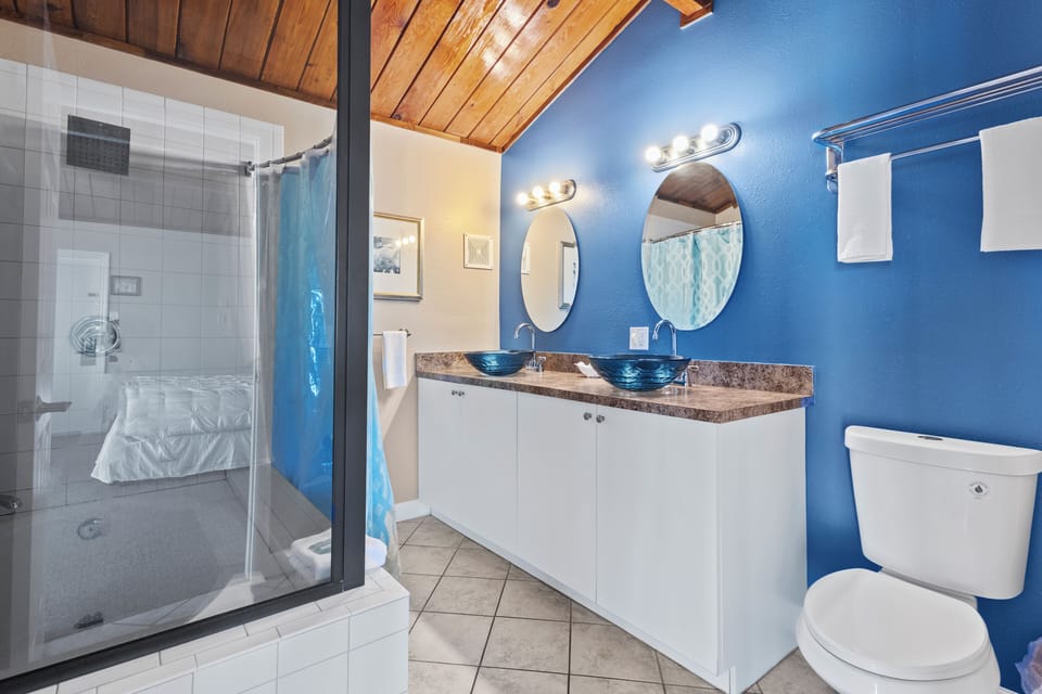 Large bathroom with tub, shower, and dual sinks.