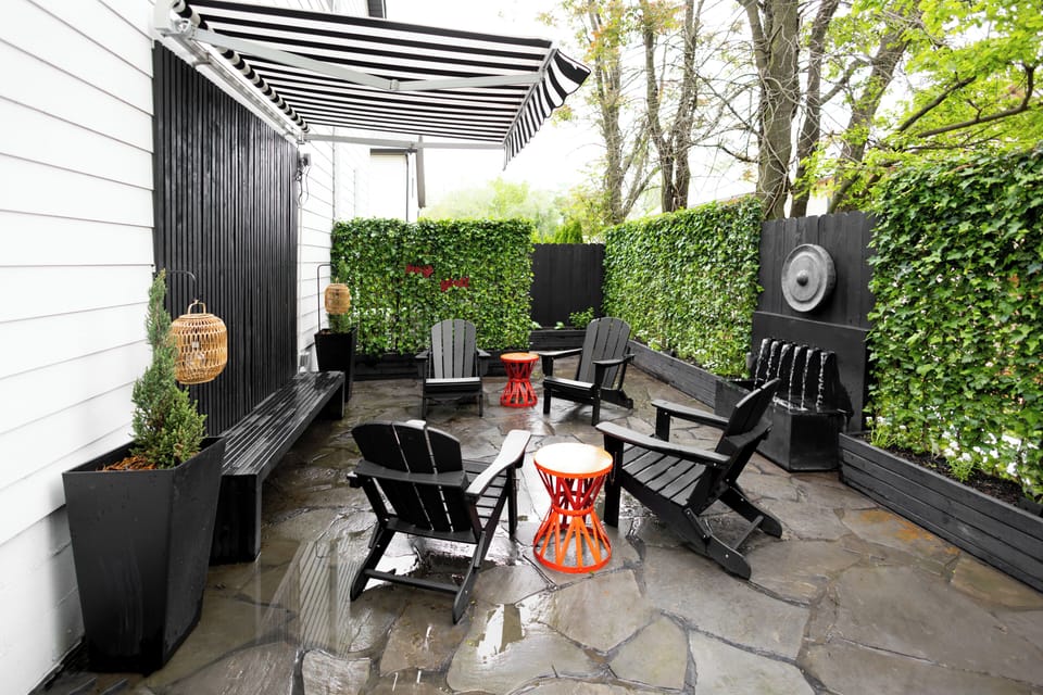 Secret garden includes seating for six, fountain, Weber BBQ, exterior night lighting, custom art sculpture, and retractable awning.