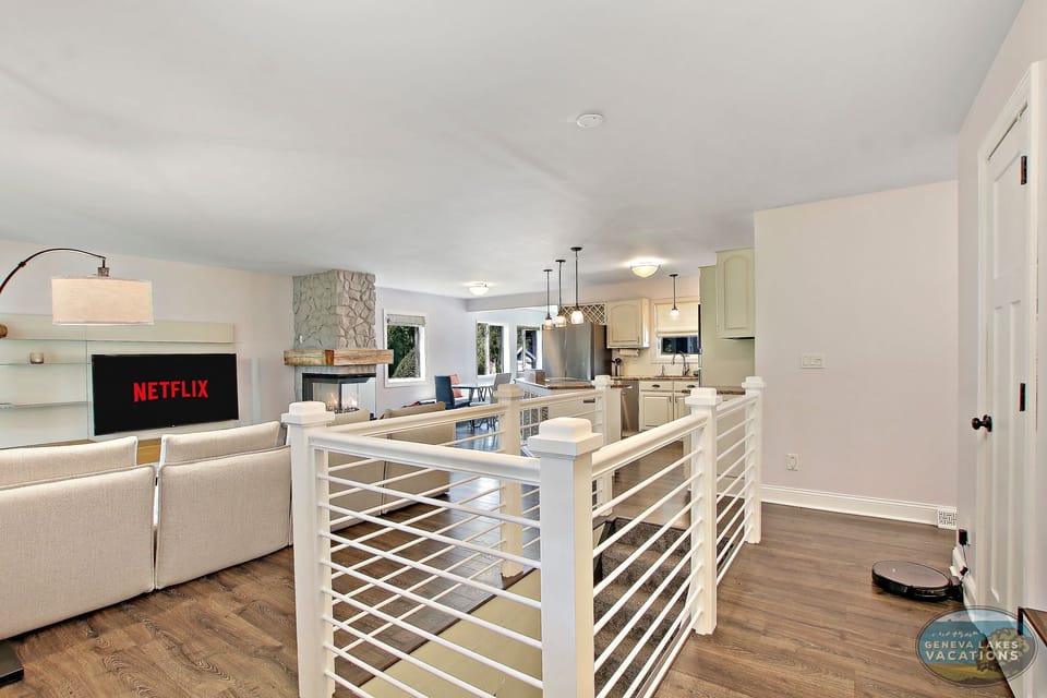 Open-concept living room kitchen, smart TV, stairway to basement.