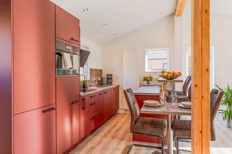 Bold red kitchen & dining area, fully equipped & ready for a home-cooked meal together.