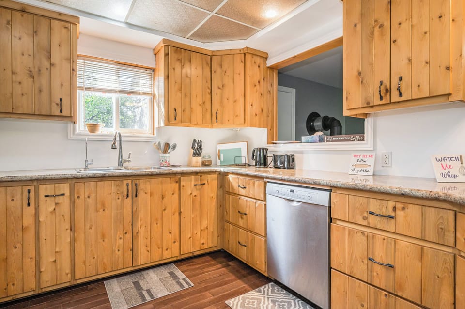 The well-equipped kitchen with modern appliances and wooden cabinetry, ideal for preparing delicious meals during your stay.