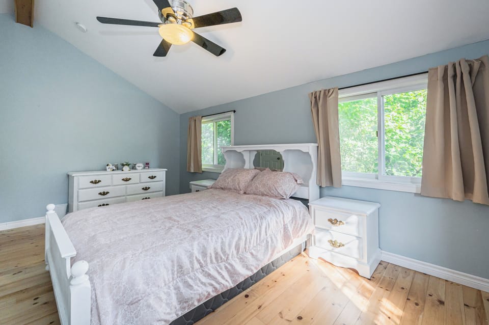 Enjoy the natural light streaming into this well-appointed bedroom, featuring a comfortable bed and ample storage.