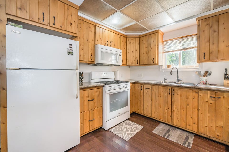 This kitchen corner offers plenty of counter space, a double sink with a view, and modern appliances, making it a delightful space to prepare delicious meals.