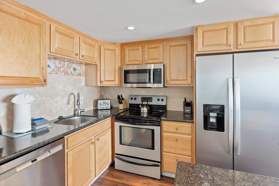 Enjoy a fully equipped kitchen with sleek appliances, perfect for creating family meals during your beachfront getaway.'