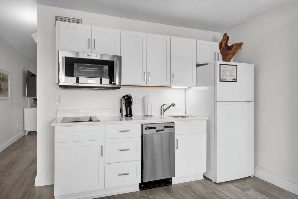 Your fully equipped kitchenette features modern stainless steel appliances, crisp white cabinetry, and everything you need to prepare meals during your stay.