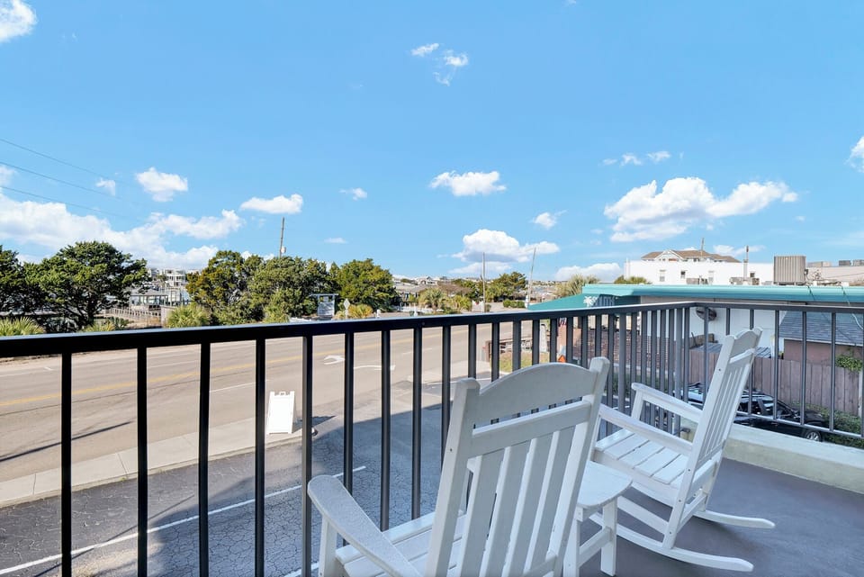 Relax in your private balcony chairs while taking in the peaceful neighborhood views and blue skies above.