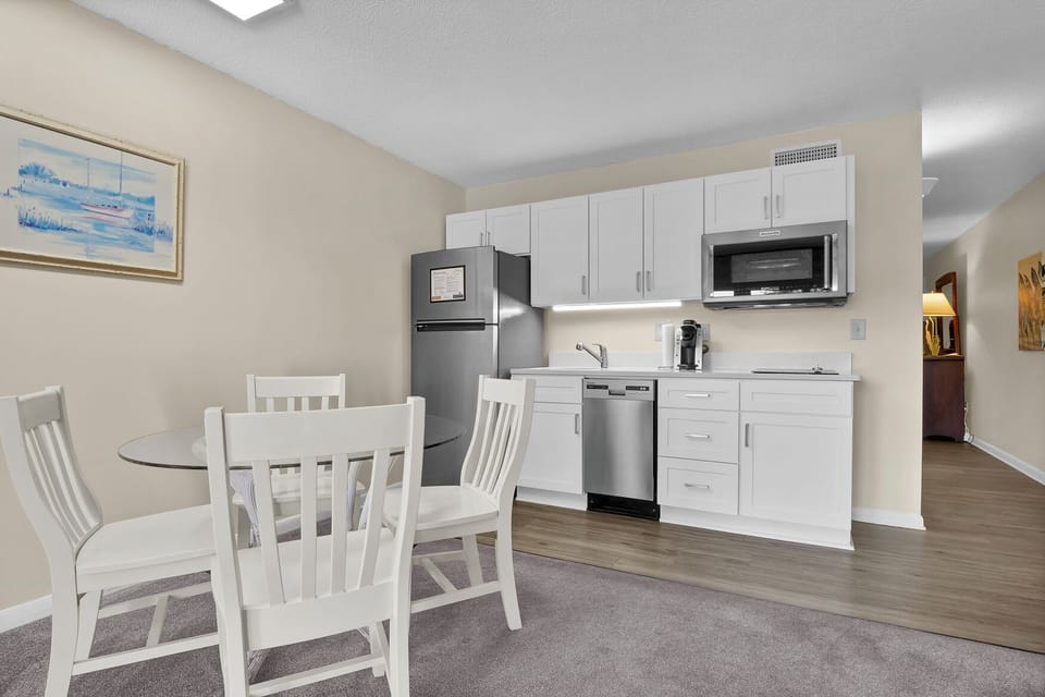 Your modern kitchen features stainless steel appliances and a dishwasher, with a cozy dining table where you can enjoy meals together.