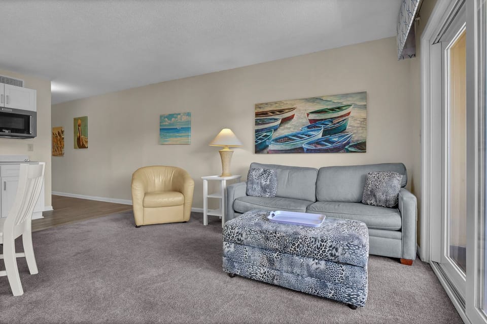 Unwind in your comfortable living space featuring coastal artwork, plush seating, and all the amenities you need for a relaxing stay.