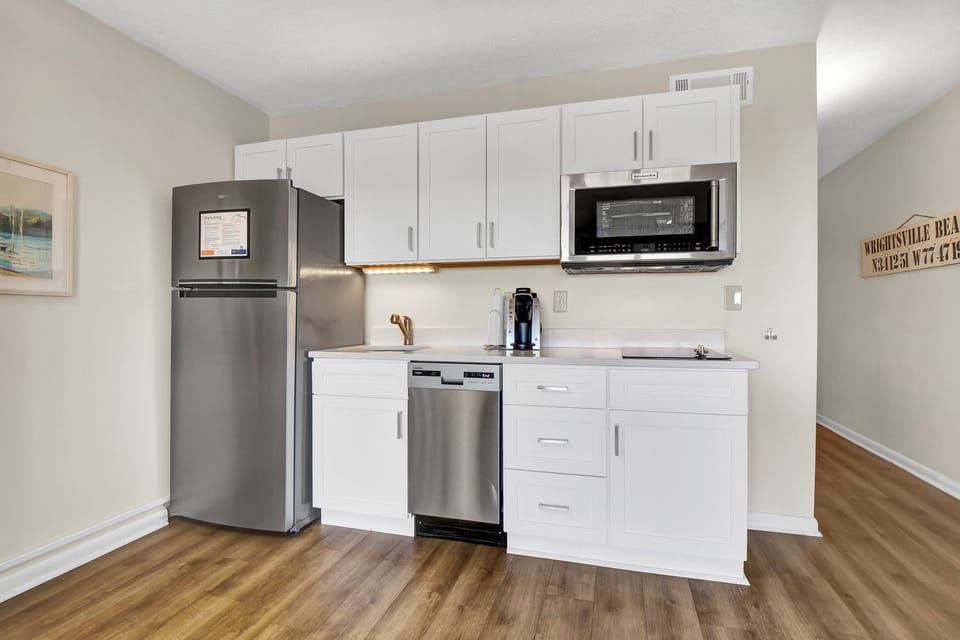 Your sleek kitchenette features stainless steel appliances and bright white cabinetry, perfect for preparing meals during your stay.