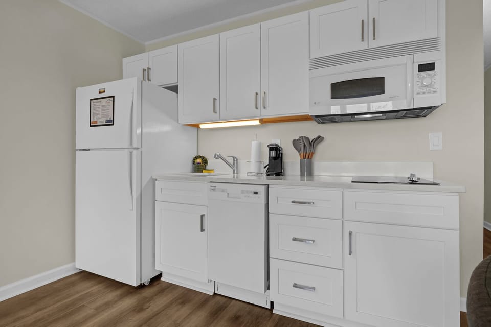 Kitchen, with two burner induction stove top, microwave and convection oven, sink, Keurig, and dishwasher