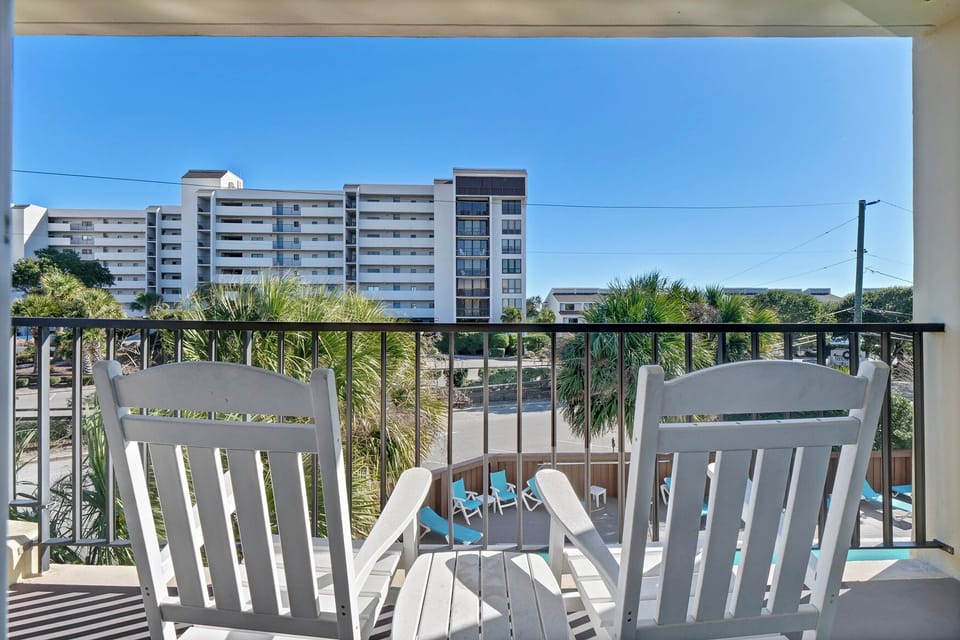 Relax on your private balcony with comfortable seating while enjoying tropical views and the sparkling pool below.