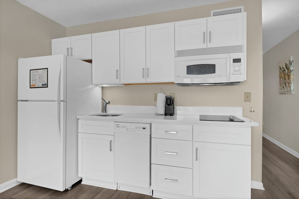 Your bright kitchenette features modern white cabinetry, full appliances, and everything you need for convenient meal prep during your stay.