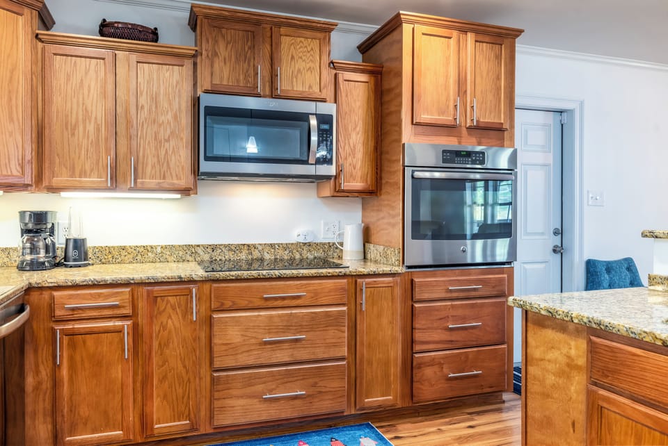 Your gourmet kitchen features rich oak cabinetry, granite counters, and premium stainless appliances ready for memorable meal preparation.