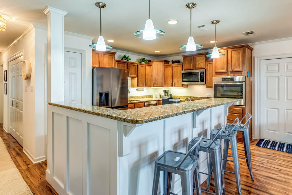 Your fully equipped kitchen invites culinary adventures with granite counters, stainless appliances, and a breakfast bar perfect for morning coffee.
