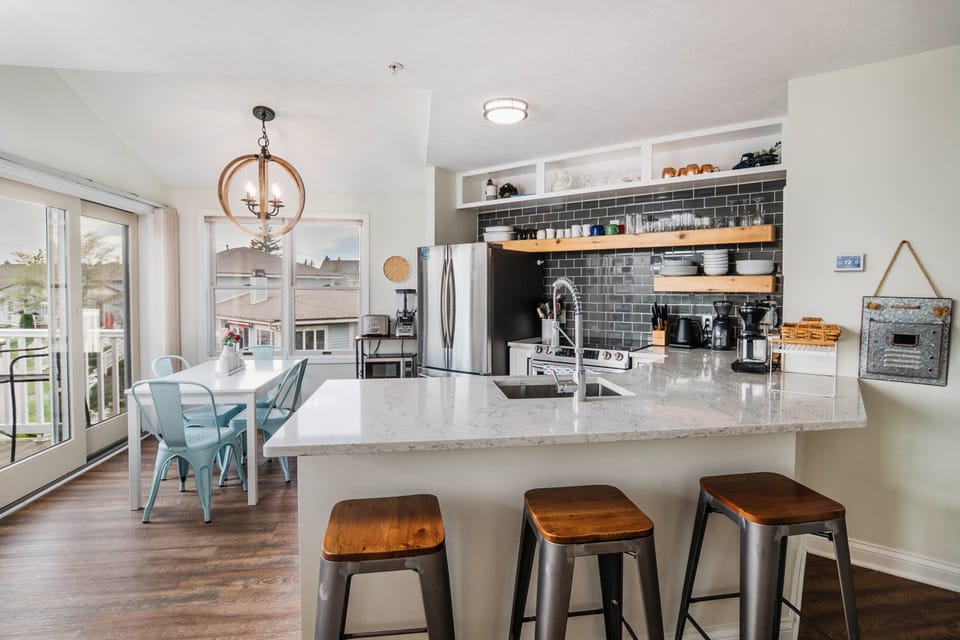 A well provision updated kitchen, with countertop seating and a dining table 
